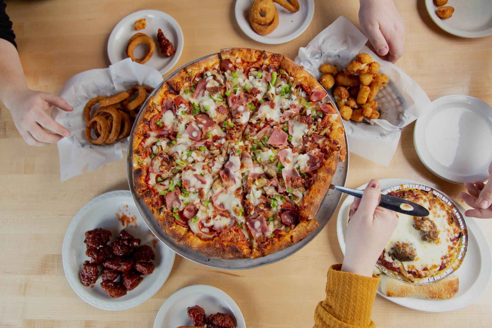 Sir Pizza and a spread of RJ’s pub favorites shared around the table