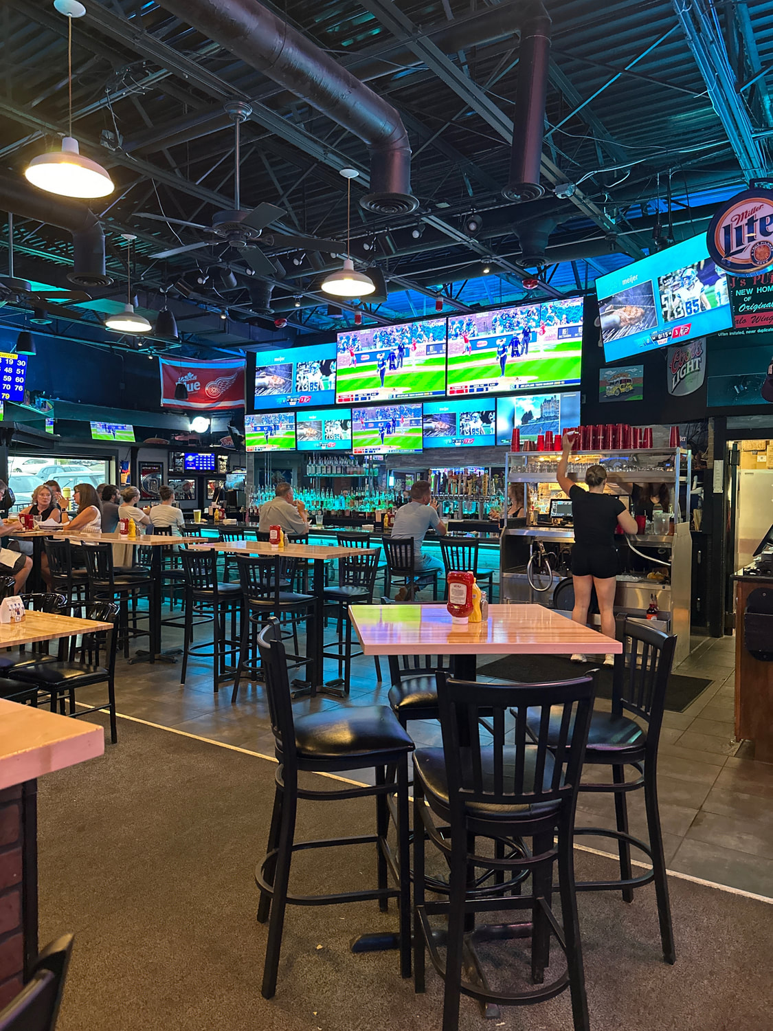 Friends gathered inside RJ’s Pub with games on the big screens